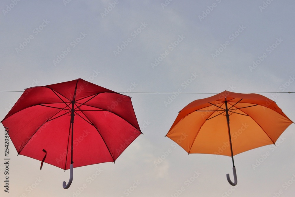 orange and red umbrellas floating on the air, isolate on the background, sunset sky.