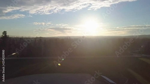 Dynamic drone shot above baseball diamonds near a road and subdivison at sunset. photo