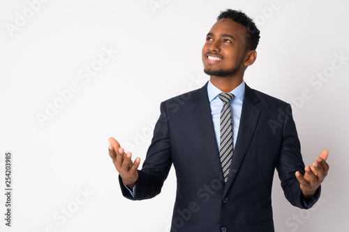 Portrait of happy young African businessman in suit catching something