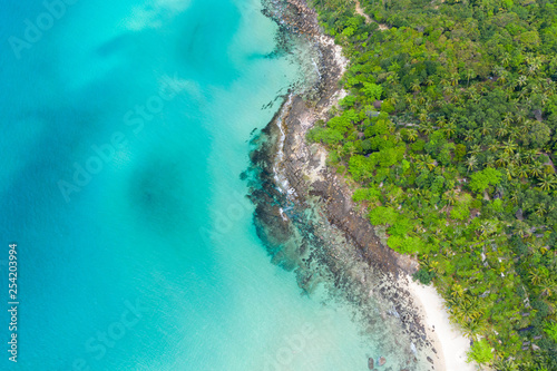 Aerial top view of ocean waves, beach and rocky coastline and beautiful forest. Beautiful nature background. © Sunday Stock