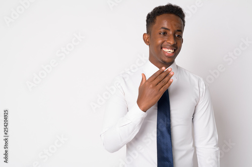 Portrait of happy young African businessman thinking and laughing