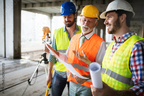 Engineer and construction site manager dealing with blueprints and plans