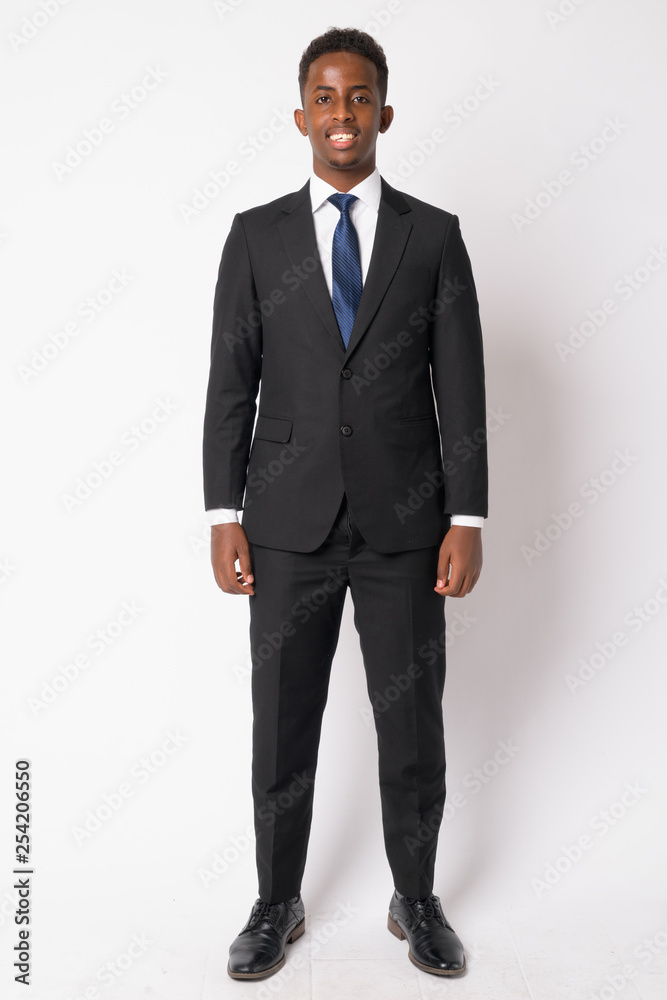 Full body shot of happy young African businessman in suit smiling Full body shot of happy young African businessman in suit smiling