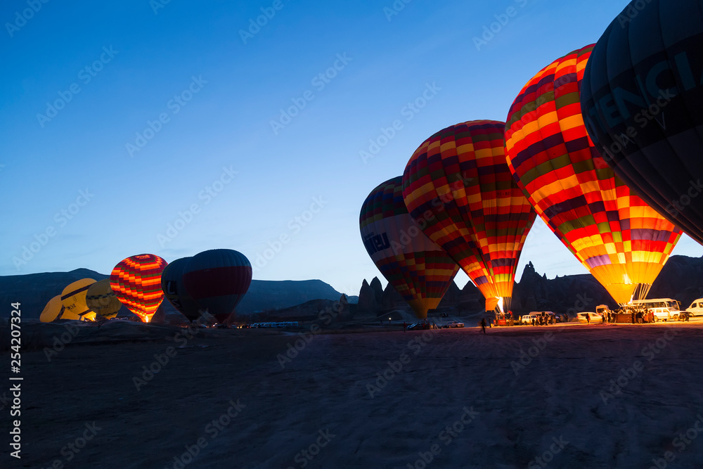 Obraz premium the balloons get ready to departure in Cappadocia from Turkey. People watch them in morning times.