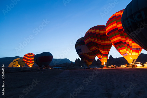 the balloons get ready to departure in Cappadocia from Turkey. People watch them in morning times.