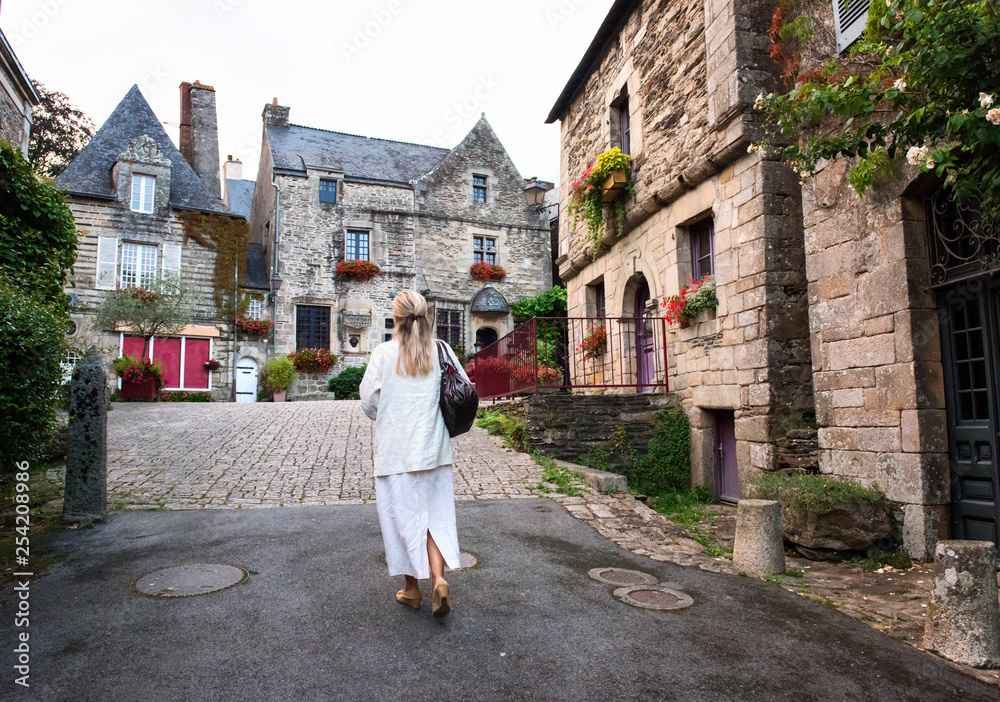People and travel concept. Woman walking in the street of an old town, historical centre of the town, Rochefort-en-Terre, France
