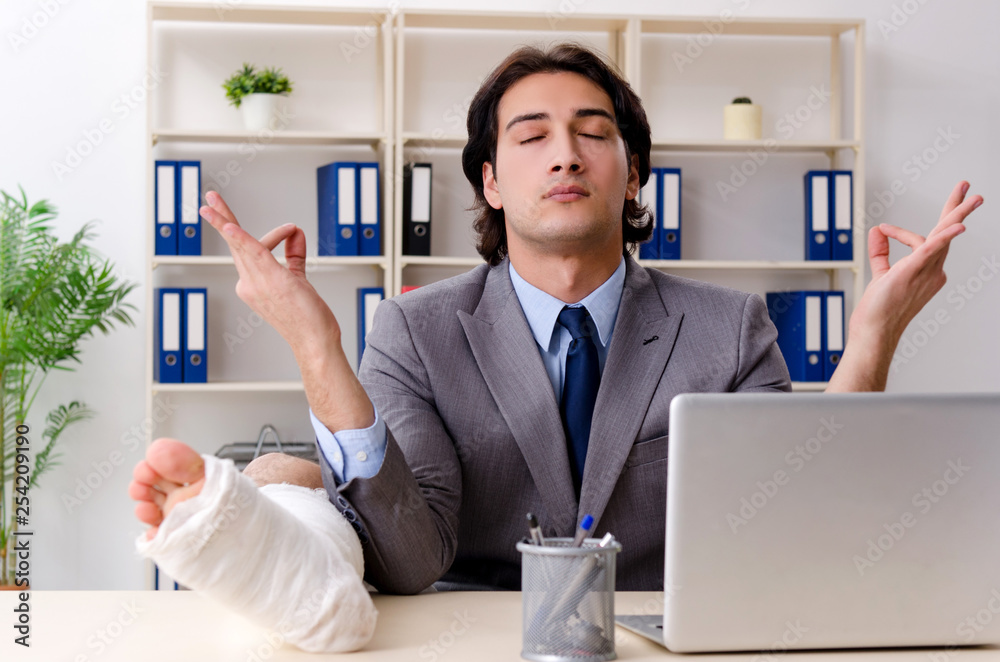 Leg injured employee working in the office Leg injured employee working in the office