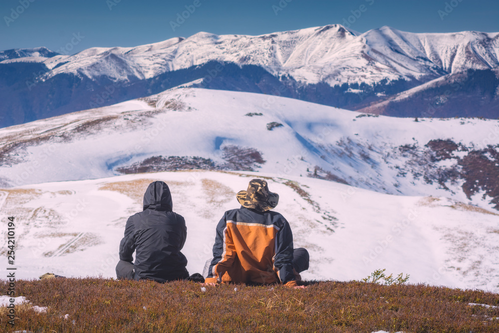 Two hikers siting on a hill
