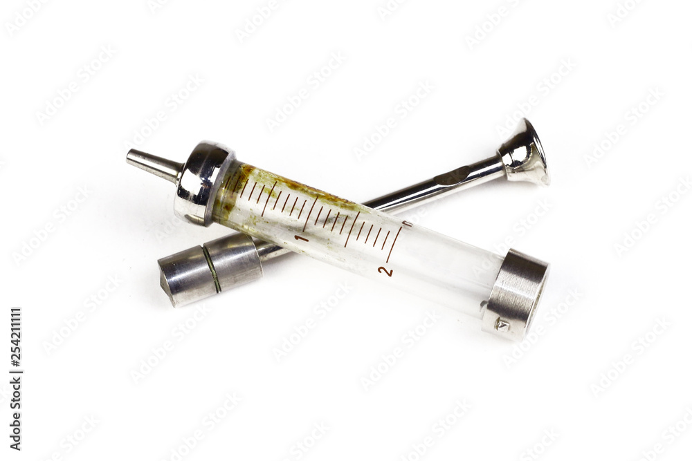 An antique medical syringe isolated on white background. An antique medical syringe isolated on white background.