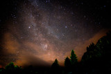 Starry nigjt on the mountains with the Milky Way and pine trees