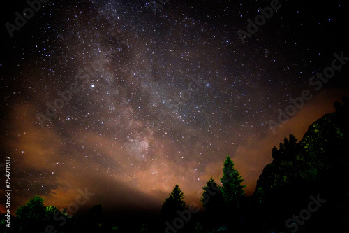 Starry nigjt on the mountains with the Milky Way and pine trees photo