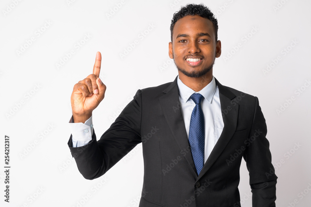 Happy young handsome African businessman pointing up Happy young handsome African businessman pointing up