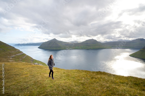 Young woman hiking near the town of Klaksvik, Bordoy, Faroe Islands