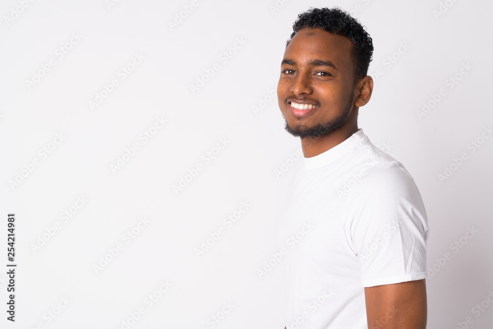 Profile view of happy young handsome African man looking at camera Profile view of happy young handsome African man looking at camera