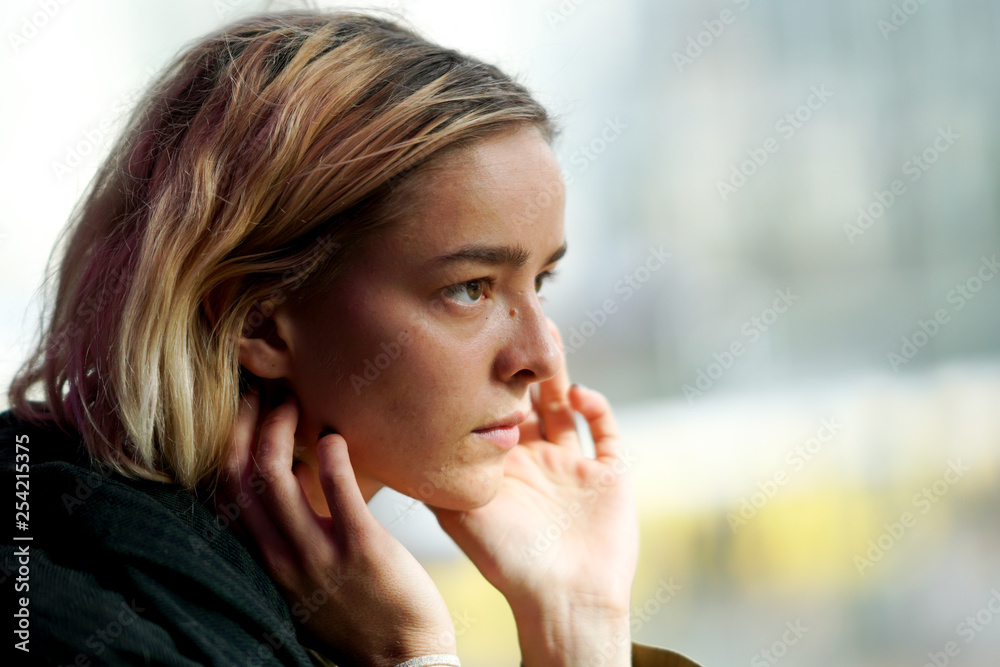 Pensive young woman looking out of the window Pensive young woman looking out of the window