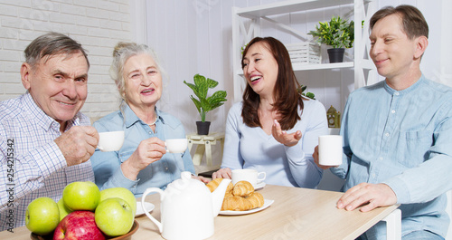 Happy family tea time at nursing home for elderly. Parents with children have fun talk communication and leisure. Senior couple and relatives. Visit old mother and father. Parenting care concept