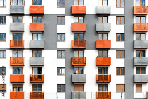 Facade of a colorful and modern multi-family building as a full frame background