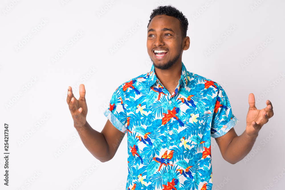 Happy young handsome African tourist man looking surprised Happy young handsome African tourist man looking surprised