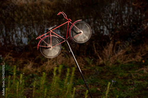Windrad in Form eines Fahrrades bei Gewitterlicht