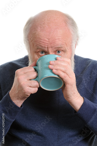 Elderly man drinking from mug, isolated on white