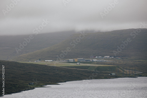 Vagar airport small international airport in the Faroe Islands in the middle of the hills on the Vagar isalnds with large tourist plane sitting on the edge of  famous Sorvagsvatn lake  photo