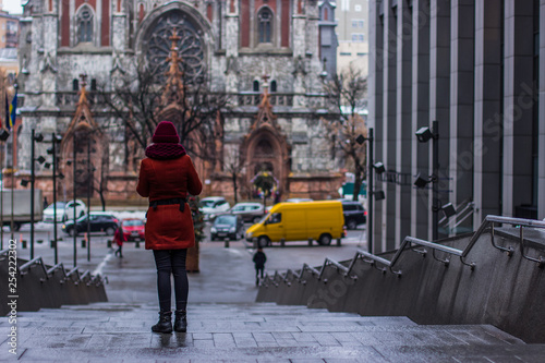 Photography woman in a coat stay back to camera in gray Ukrainian city urban building enviro