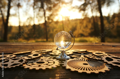 small crystal globe in front of sunset. travel and global issues concept photo