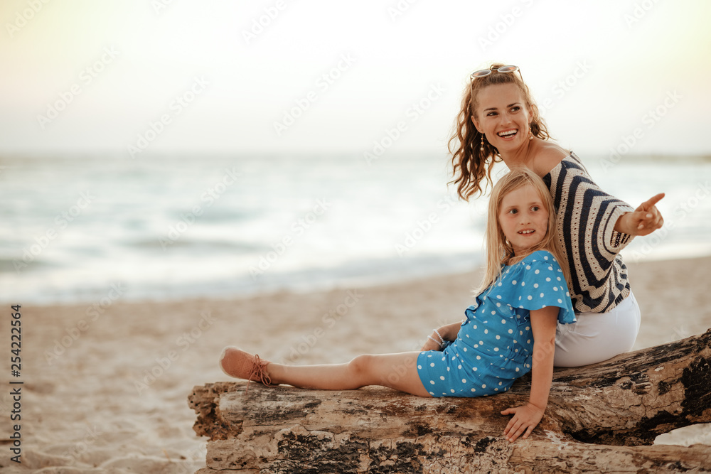 mother and child pointing at something while sitting on a wooden mother and child pointing at something while sitting on a wooden