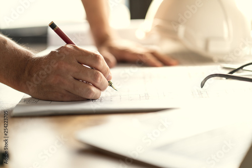 Architect   Engineer working drawing document about project planning and progress of work schedule on the home building construction site
