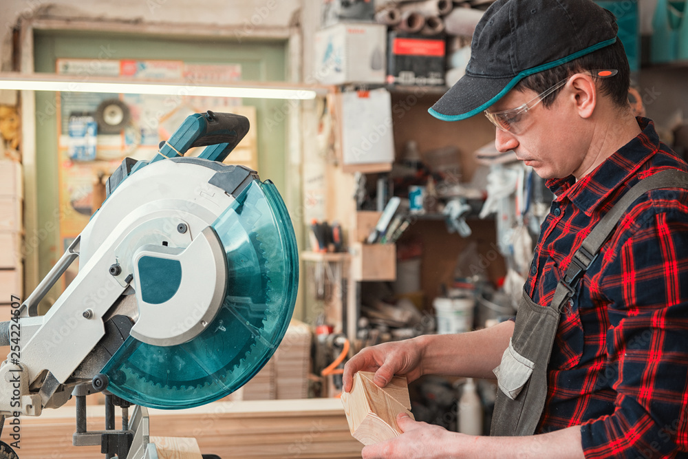 Construction worker cutting wooden board with circular saw Construction worker cutting wooden board with circular saw