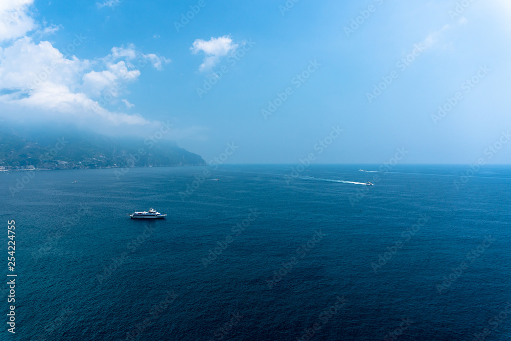 Marvelous view from amalfi coast of beautiful blue sea, mountains, cliffs and floating ships at sea.