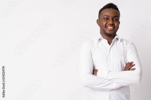 Portrait of happy young African businessman smiling with arms crossed