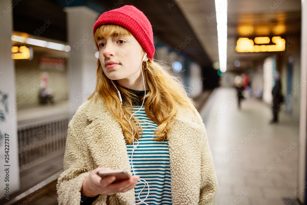 junge Frau wartet in einer U-Bahn Station auf den Zug junge Frau wartet in einer U-Bahn Station auf den Zug