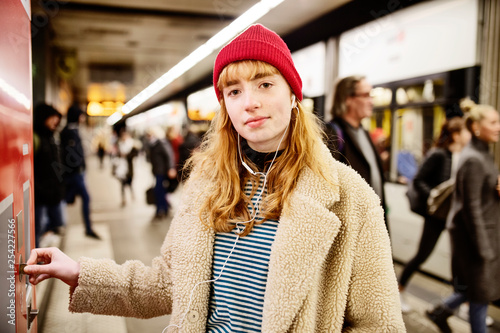 junge Frau kauft auf dem Bahnsteig eine Fahrkarte