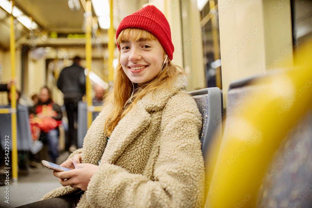 junge Frau, Mädchen, Teenager, sitzt mit ihrem Smartphone, Handy, in der U-Bahn junge Frau, Mädchen, Teenager, sitzt mit ihrem Smartphone, Handy, in der U-Bahn