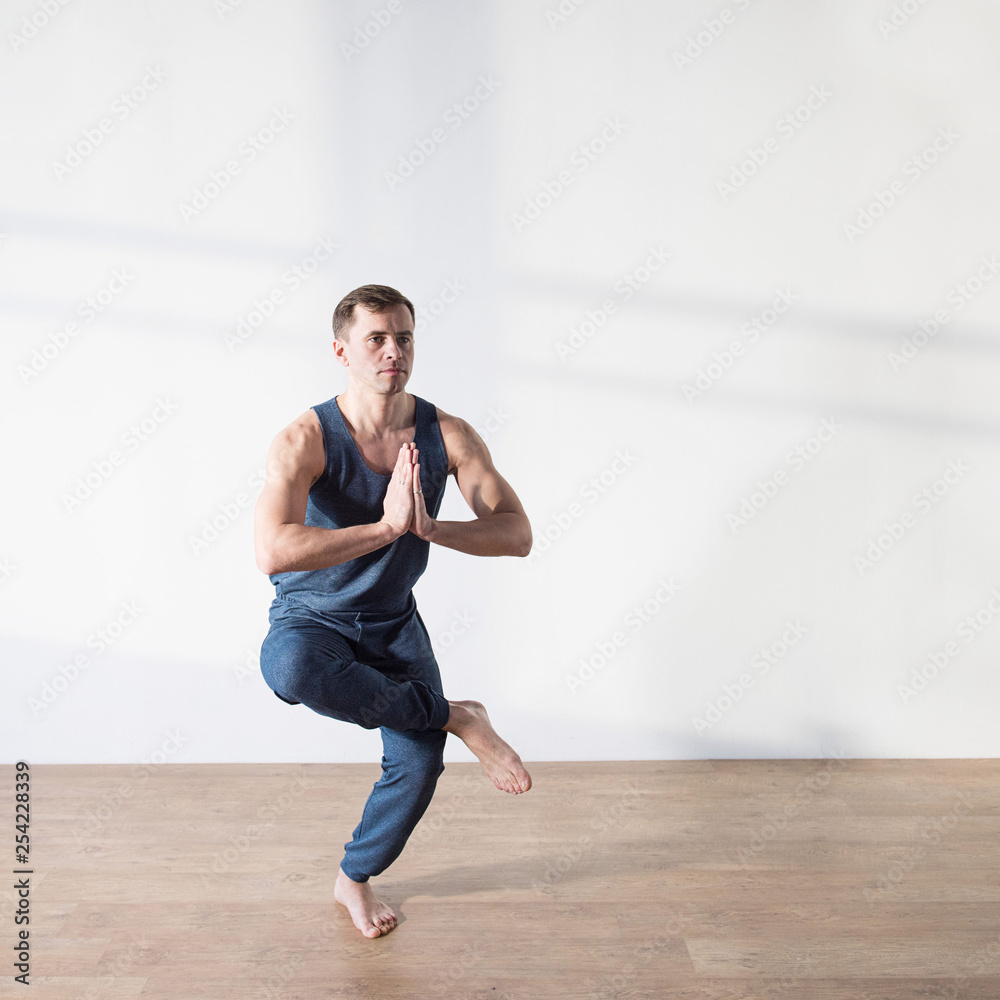 Fototapeta premium Young man doing yoga indoor. Workout Exercise Fitness Health Concept.