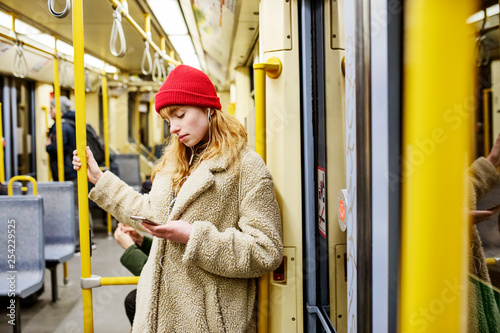 junge Frau, Mädchen, Teenager, mit Smartphone, fährt mit der U-Bahn  photo