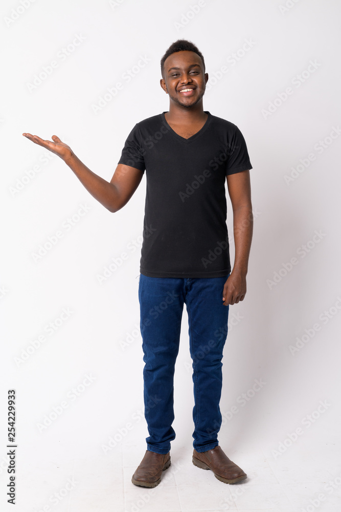 Full body shot of happy young African man showing something Full body shot of happy young African man showing something