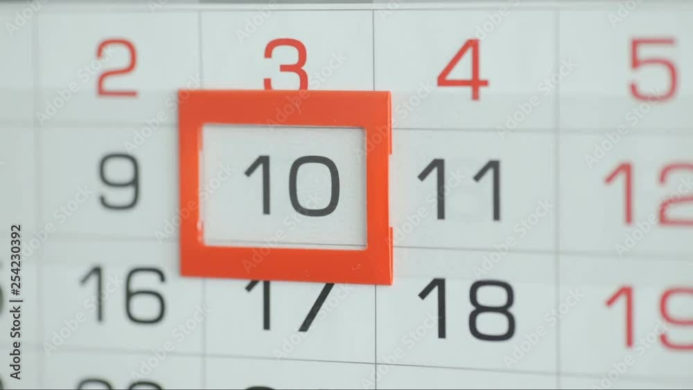 Woman's hand in office changes date at wall calendar. Changes 9 to 10 Woman's hand in office changes date at wall calendar. Changes 9 to 10