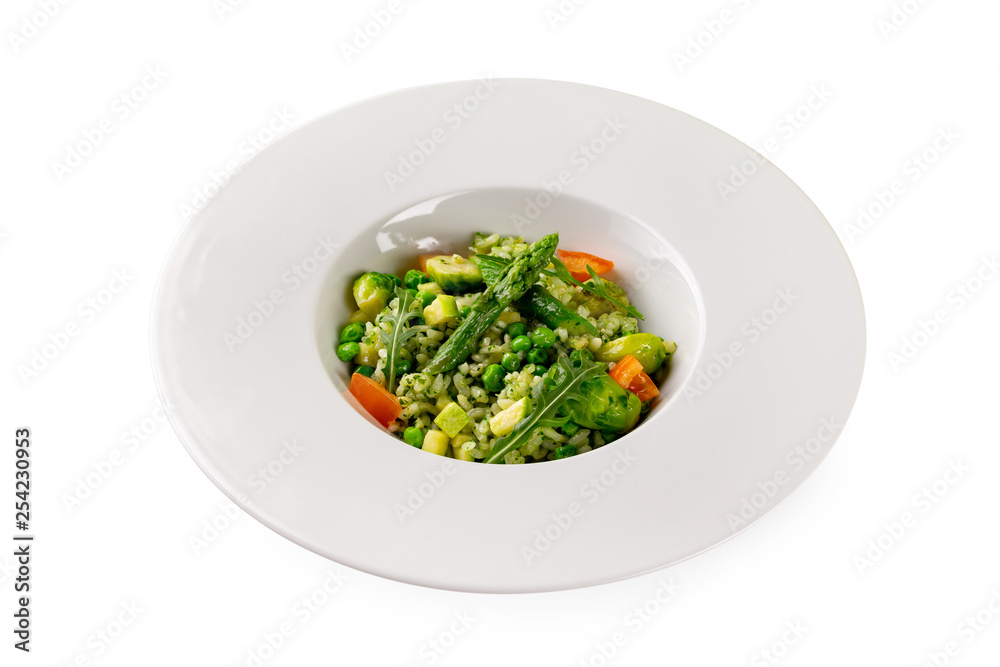 Plate of italian risotto with green beans, peas, tomato, zucchinis and rice isolated at white background.