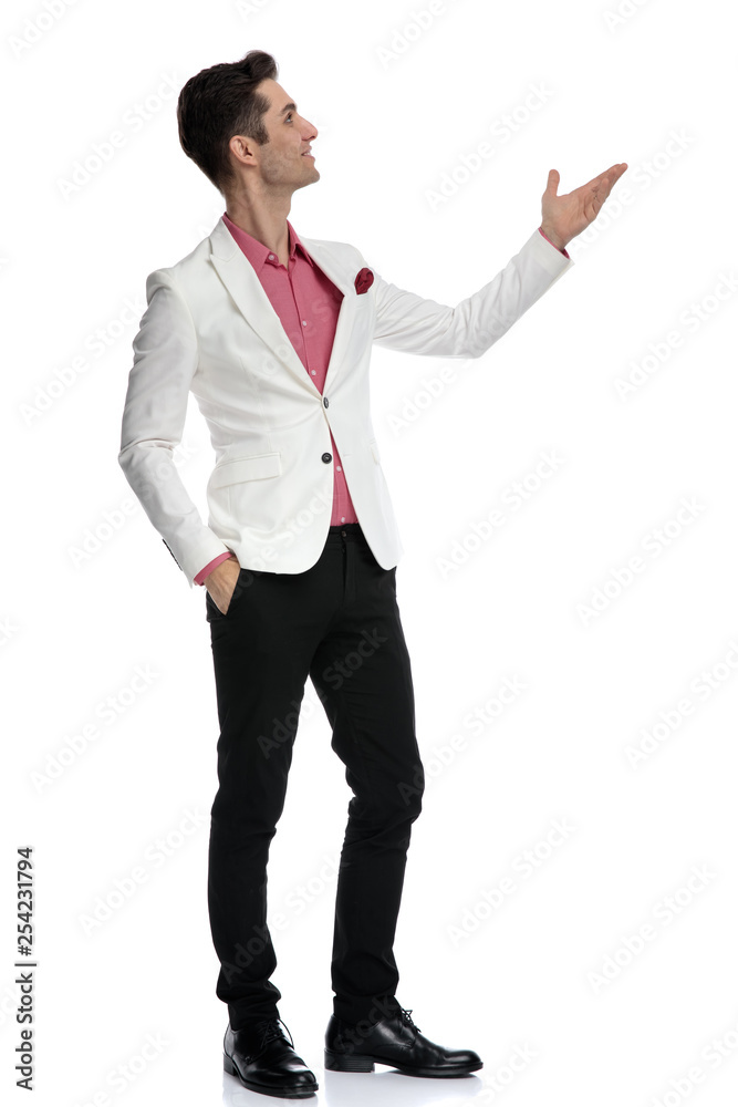 side view of a young elegant man showing something up side view of a young elegant man showing something up