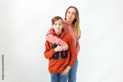 Mothers day, children and family concept - teen boy hugging his mom on white background with copy space photo