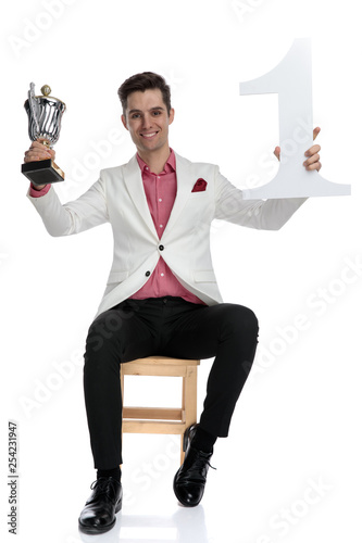 young successful elgant businessman holding trophy and number one up photo