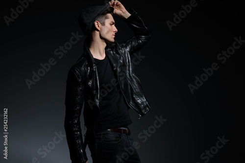 young man in leather jacket look far away to side