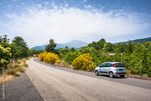 Car on the road to Etna, with volcano in background, Sicily photo