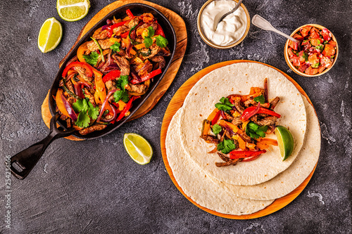 FAJITAS with colored pepper and onions, served with tortillas.