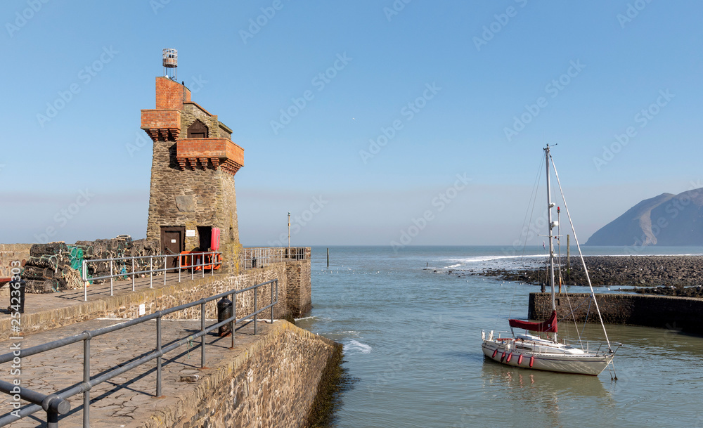 Lynmouth, North Devon, England, UK. March 2019. Lynmouth pier on the West Lyn River with the historic Rhenish Tower