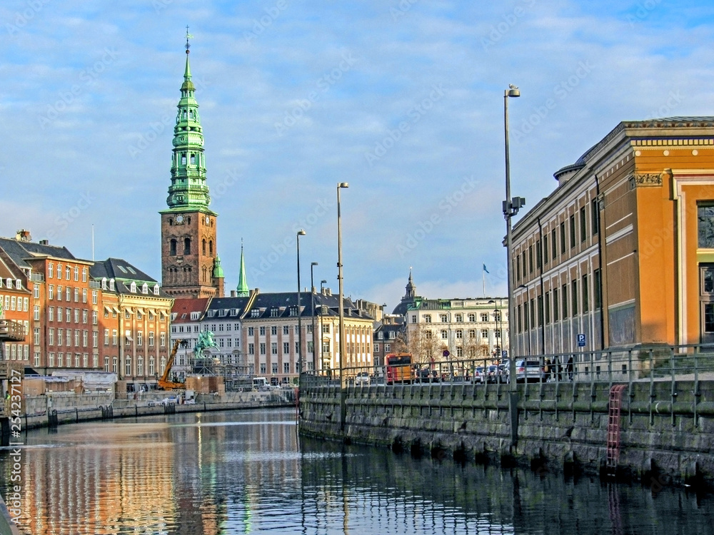 City canal and historical buildings of Copenhagen with St. Nikolaj Contemporary Art Center in Church, conspicuous landmark of Denmark