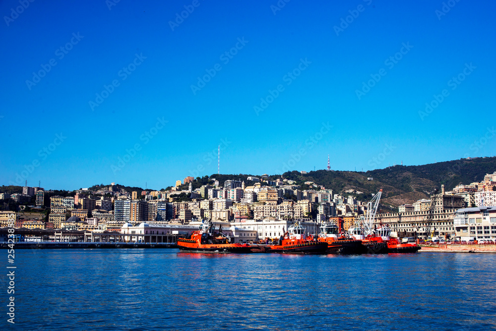  Beautiful view of the rocky mountains, the Italian city of Genoa, the port and the red boats. Blue sky with white cloud. Blue Ocean.