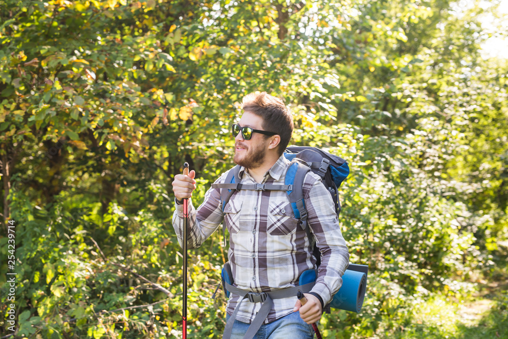 Hike, tourism and nature concept - Young traveler with backpack standing over forest background